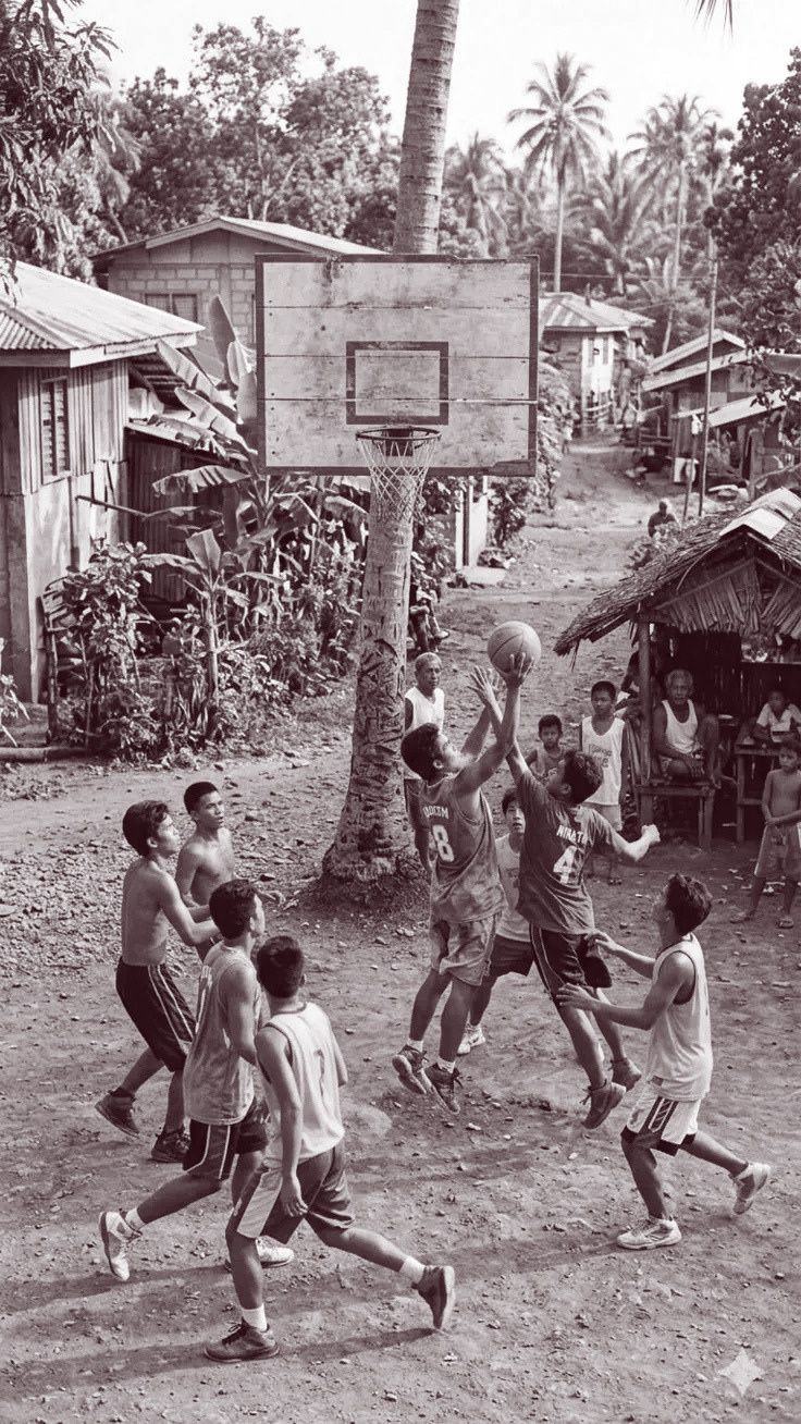 Young people playing basketball on a village court in the Philippines