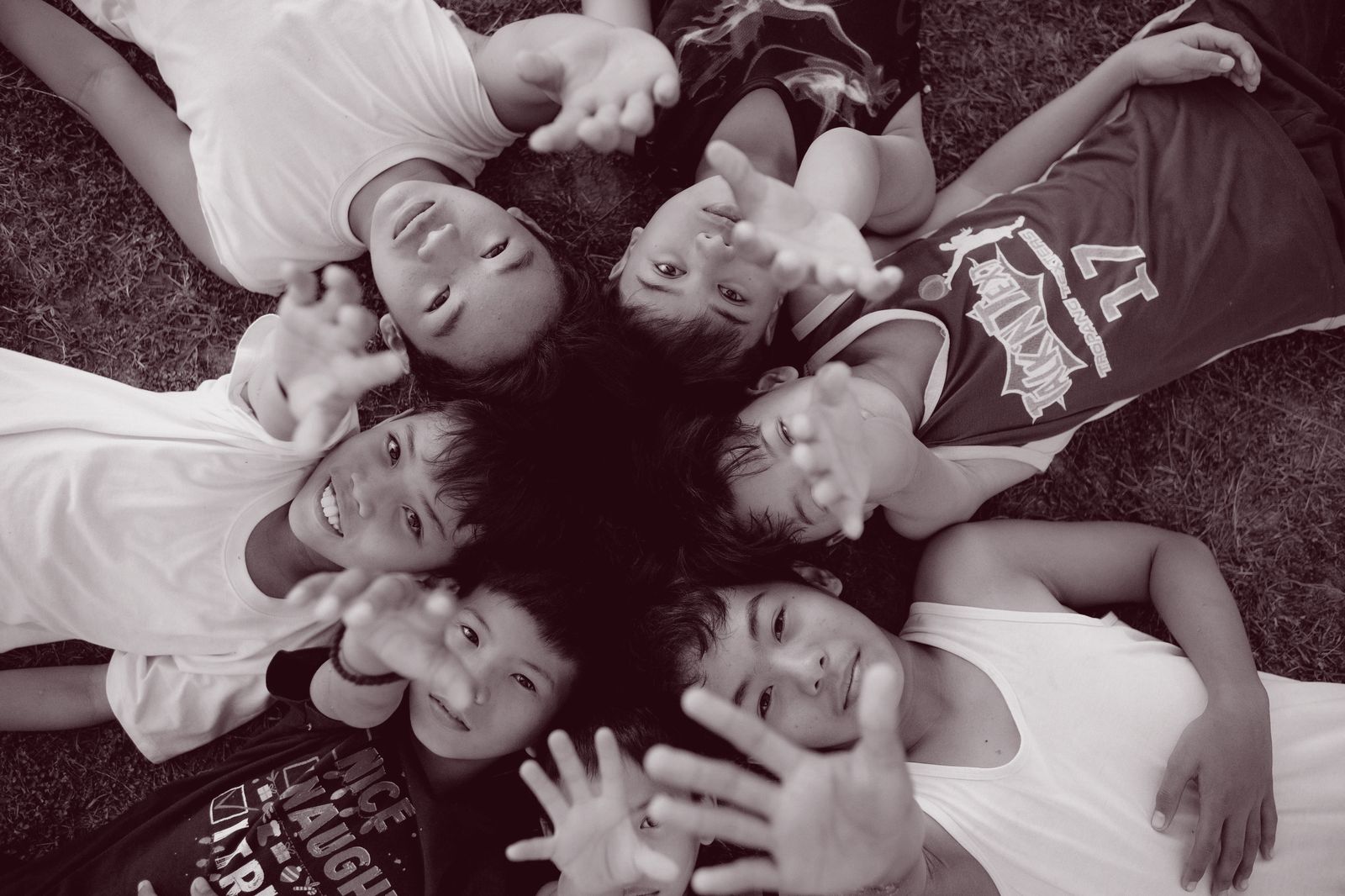 Children in a circle reaching toward the camera