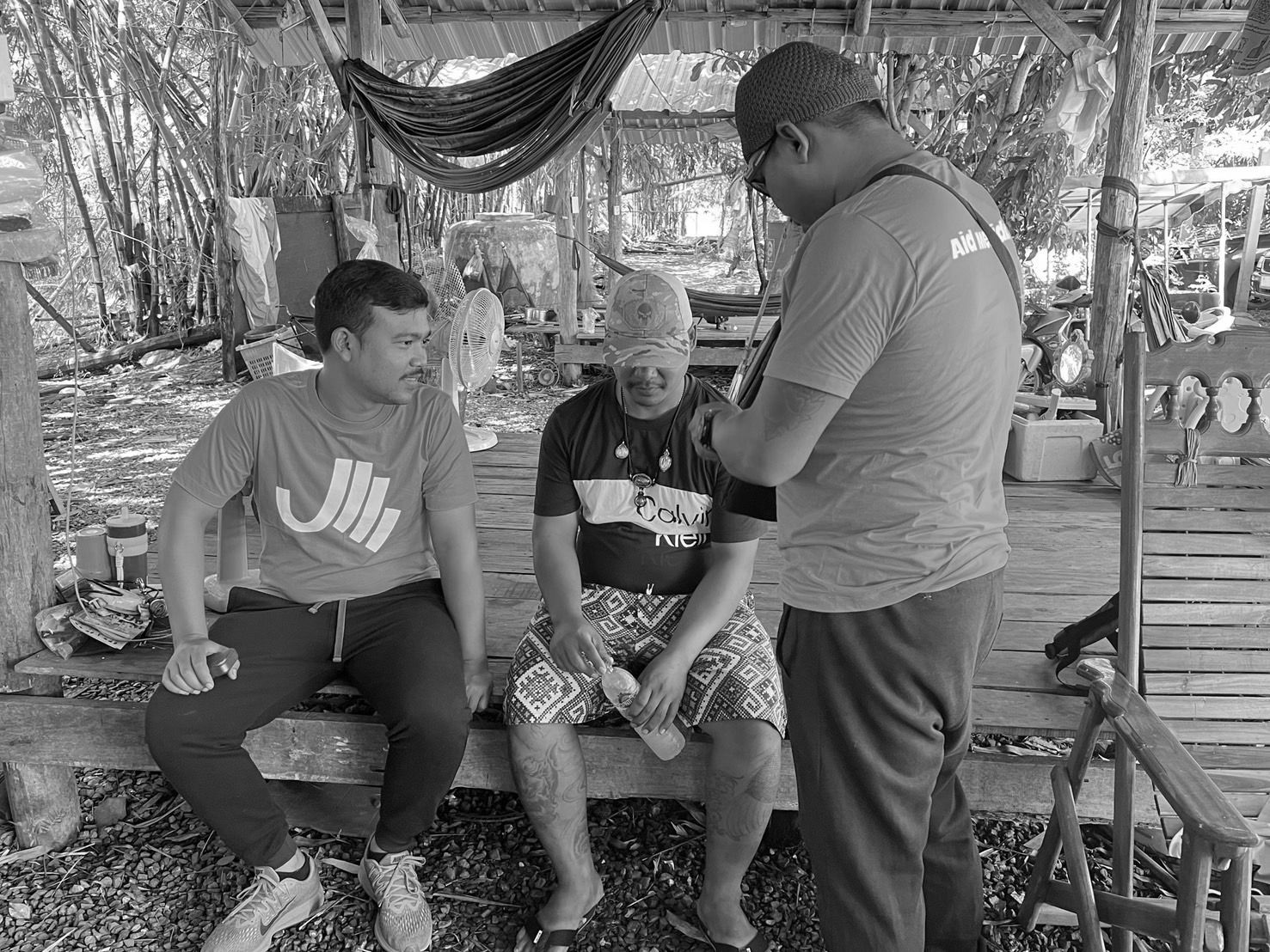 Aid Meridian team members talking with a man in a rural community in Thailand
