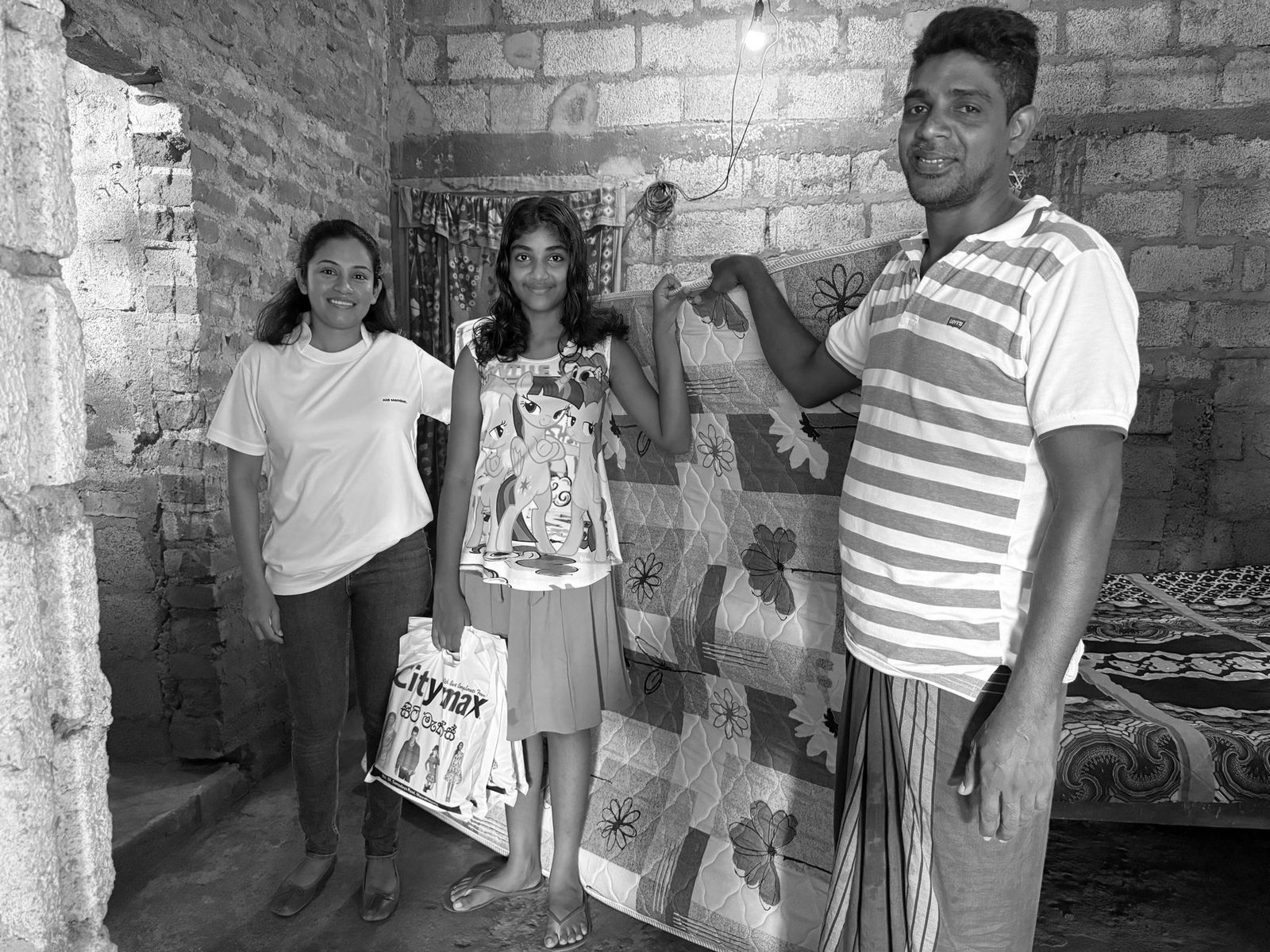 An Aid Meridian volunteer delivering a mattress and supplies to a family in Sri Lanka after the floods