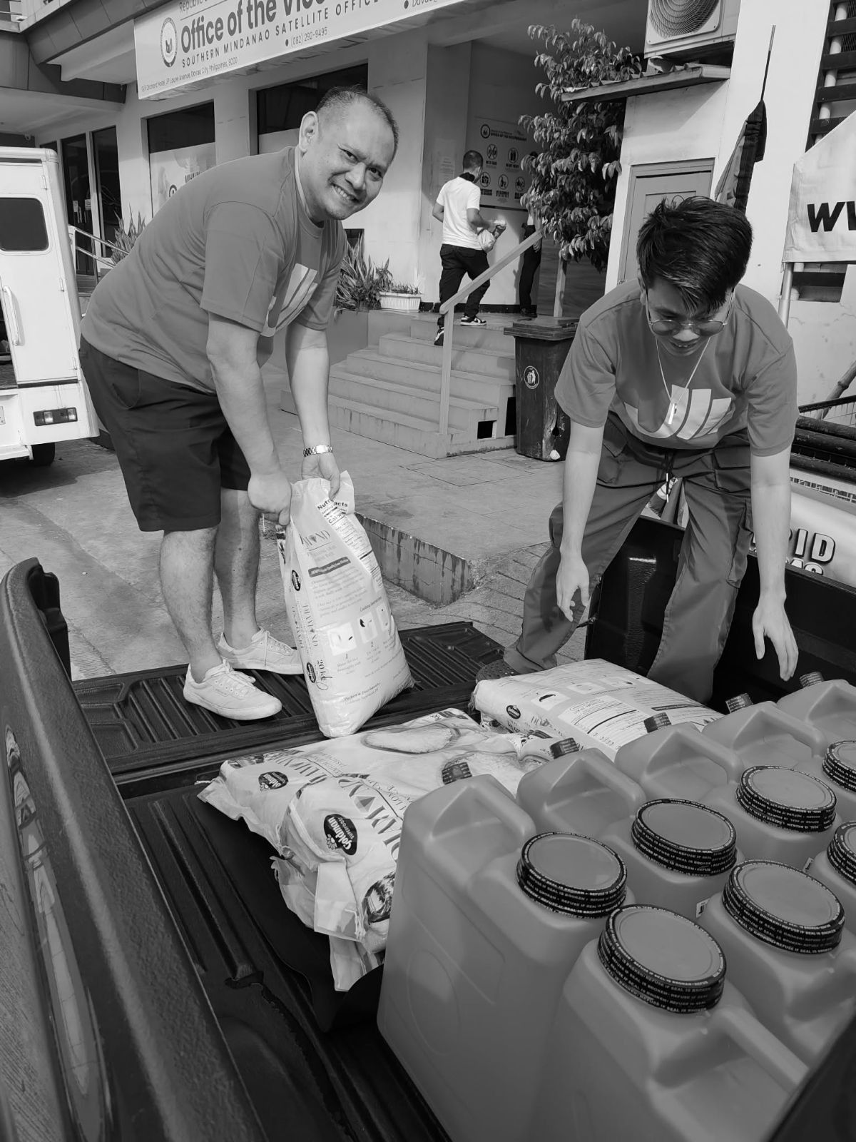 Aid Meridian volunteers loading rice and water containers onto a truck in Davao City